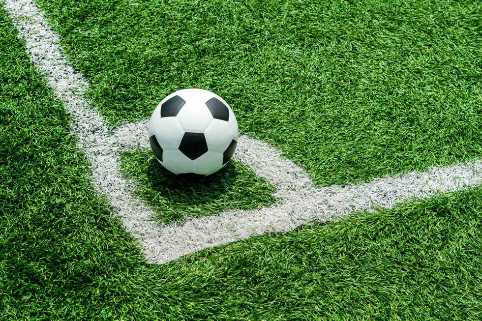 Soccer ball on grass in the corner arc of a soccer field